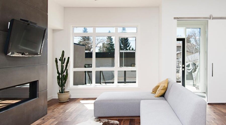 Modern metal and wood ceiling fan in a contemporary living space with tv and white couch